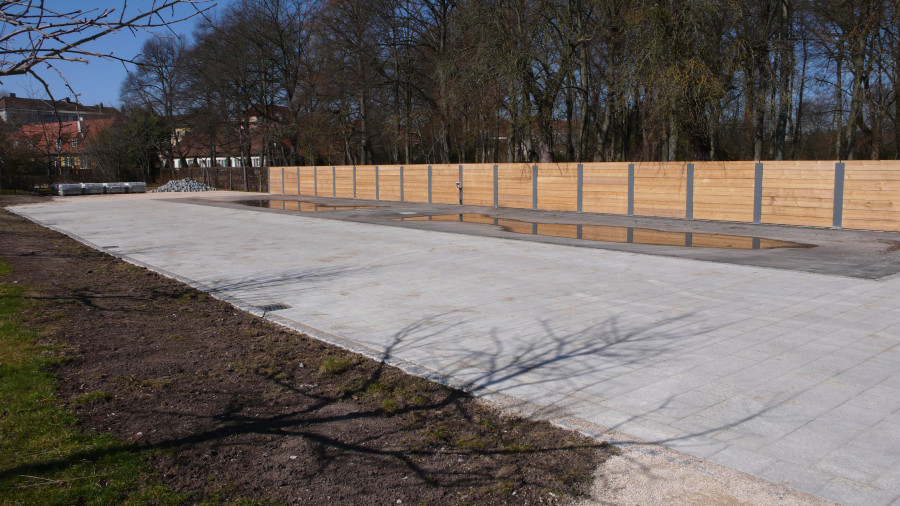 Asphaltierter Platz für Kompost in der Gärtnerei des Hofgartens Ansbach mit braunem Zaun im Hintergrund