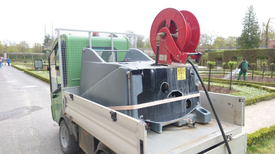 Ein Mitarbeiter der SGV Würzburg besprüht die Reihen der Rosenpflanzen mit EM-versetztem Gießwasser, das von einem Kleintransporter mit Gießvorrichtung stammt