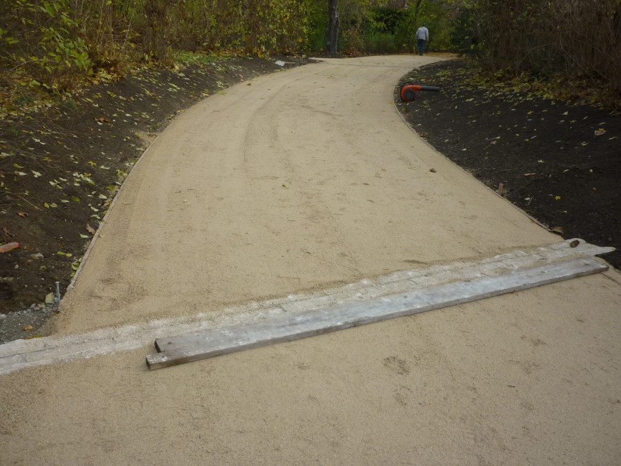 Weg im "Englischen Teil" des Hofgartens Würzburg mit fertiggestellter Querrinne aus hellem Dietfurter Kalkstein. Rechts und links des Weges ist dunkles Erdreich zu sehen